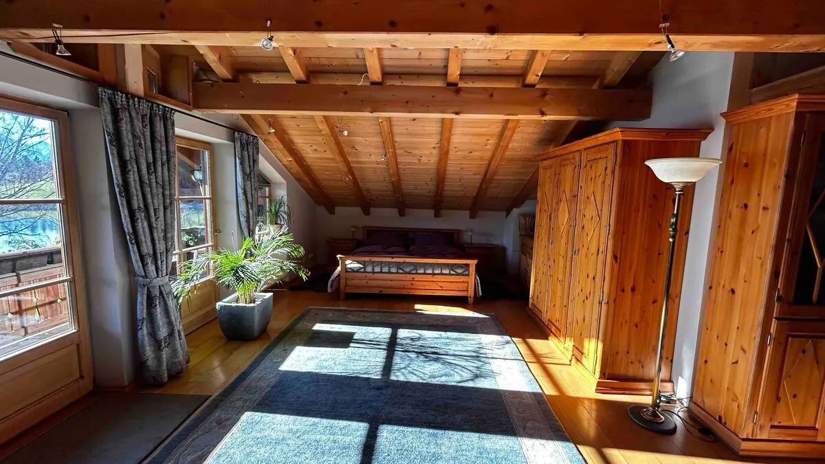 Bedroom with timber ceiling, double bed and wardrobe